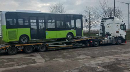 Autobus załadowany na platformę do przewozu pojazdów