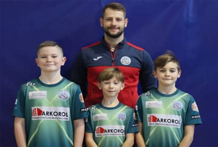 Reprezentanci z Gminy Jonkowo ze swoim trenerem. Trzech młodych piłkarzy i trener.