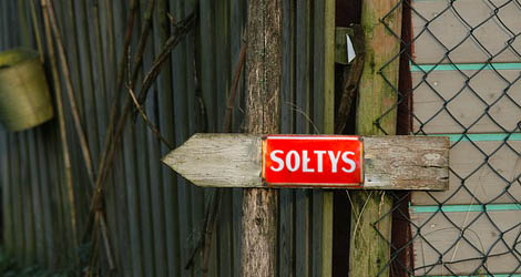 Tablica z napisem sołtys przyczepiona na płocie