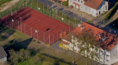 Zdjęcie przedstawiające budynek szkoły oraz boisko widziane z lotu ptaka.