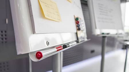 Źródło: Pixabay Zdjęcie przedstawiające dwie tablice suchościeralne z przyklejonymi kartkami papieru oraz kolorowe markery.