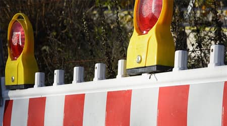 Zdjęcie przedstawiające barierę drogową z sygnalizatorami świetlnymi.