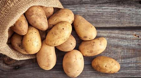 Zdjęcie przedstawiające ziemniaki wysypujące się z worka.