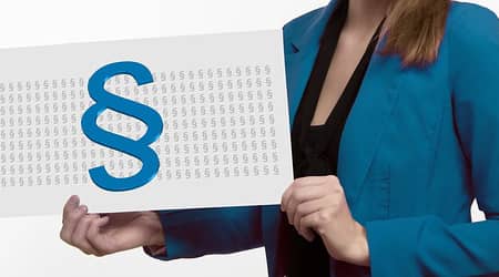 Kobieta trzymająca kartkę z symbolem paragrafu.