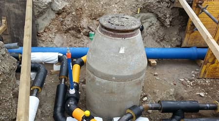 Zdjęcie rozkopanej studni kanalizacyjnej oraz rur.