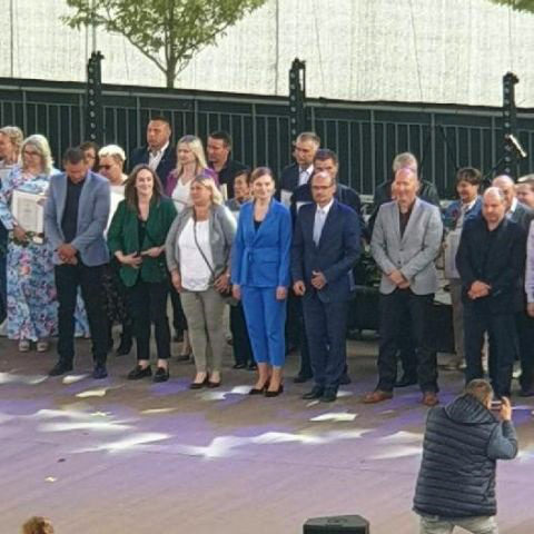 Zdjęcie grupy osób stojących na scenie.