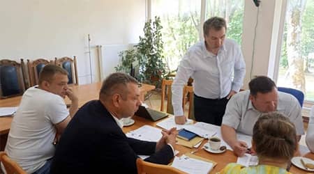 Źródło: UG Jonkowo. Pięć postaci przy stole obrad. Jedna osoba wstaje od stołu.