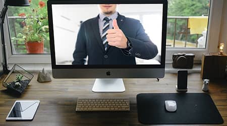 Autor zdjęcia: użytkownik Tumisu z serwisu Pixabay Postać mężczyzny na ekranie monitora stojącego na biurku.