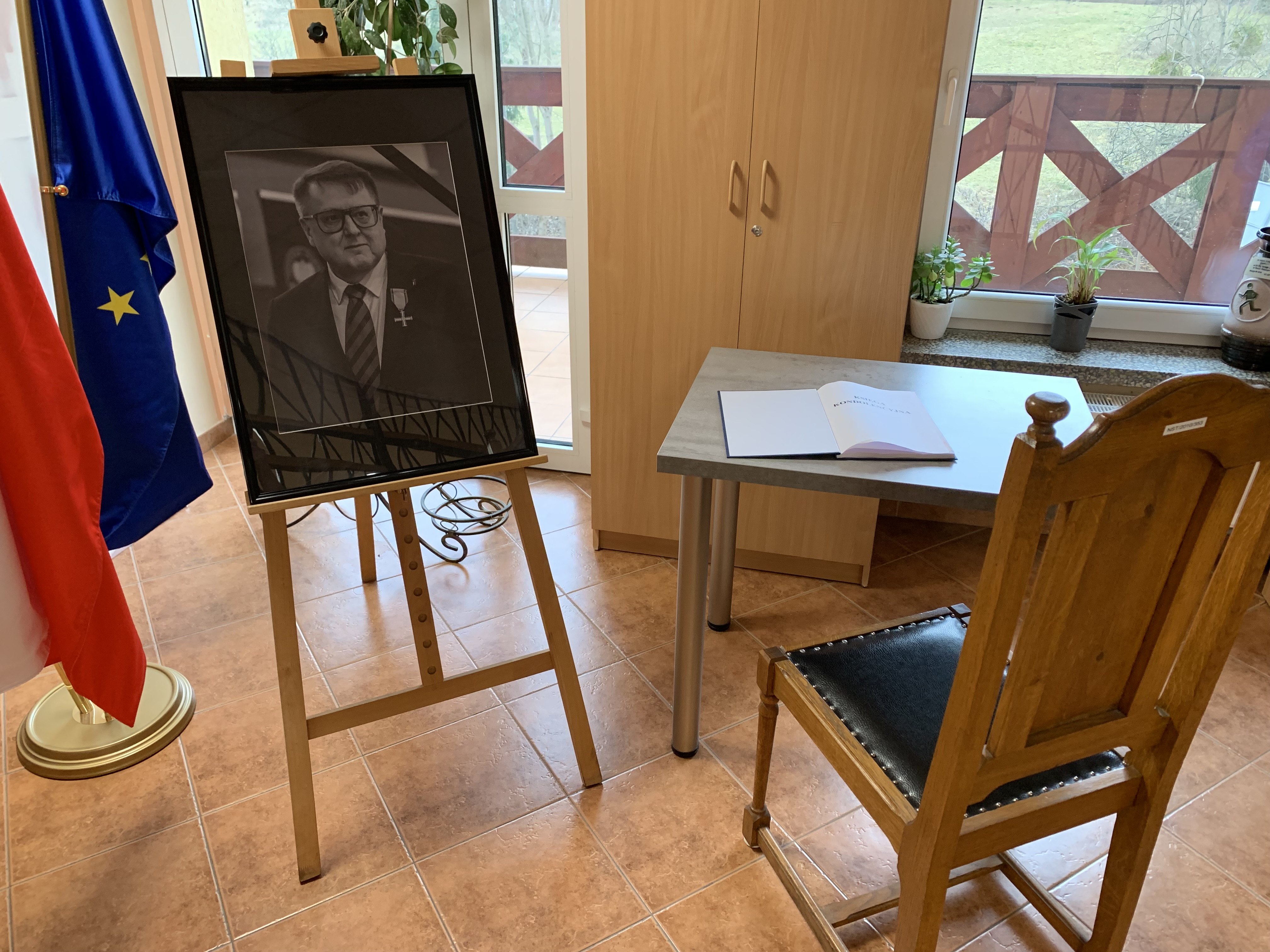 na zdjęciu fotografia tomasza Adrjana i kięga kondolencyjna