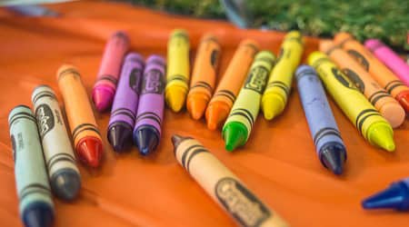 Kredki świecowe rozrzucone na stole.